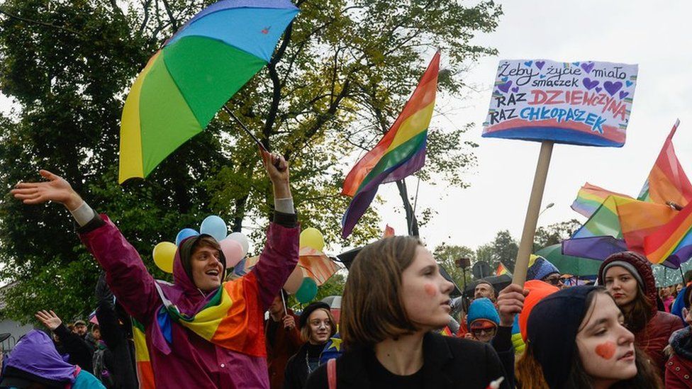 A woman holds a rainbow flag during an Equality/Pride march on October 06, 2019 in Nowy Sacz, Poland