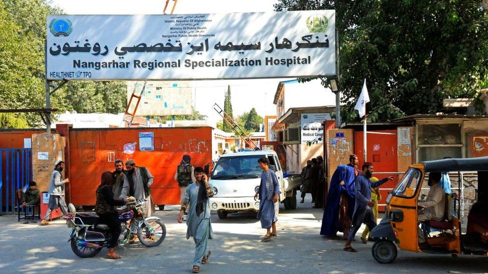 Afghan people are pictured outside the Nangarhar Regional Specialization Hospital on 18 September