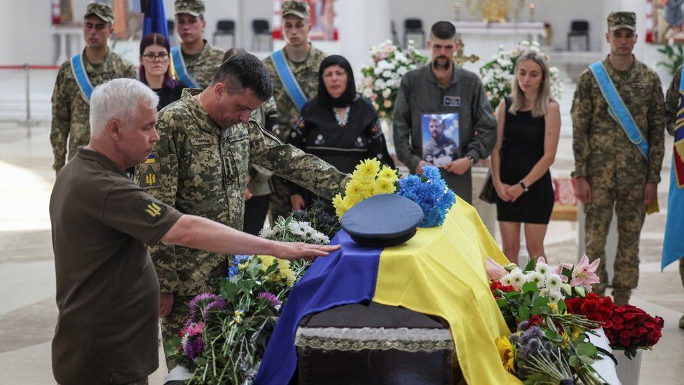 Ukraine's Air Force Commander Mykola Oleshchuk (2nd left) pays last tribute to Andrii Pilshchykov