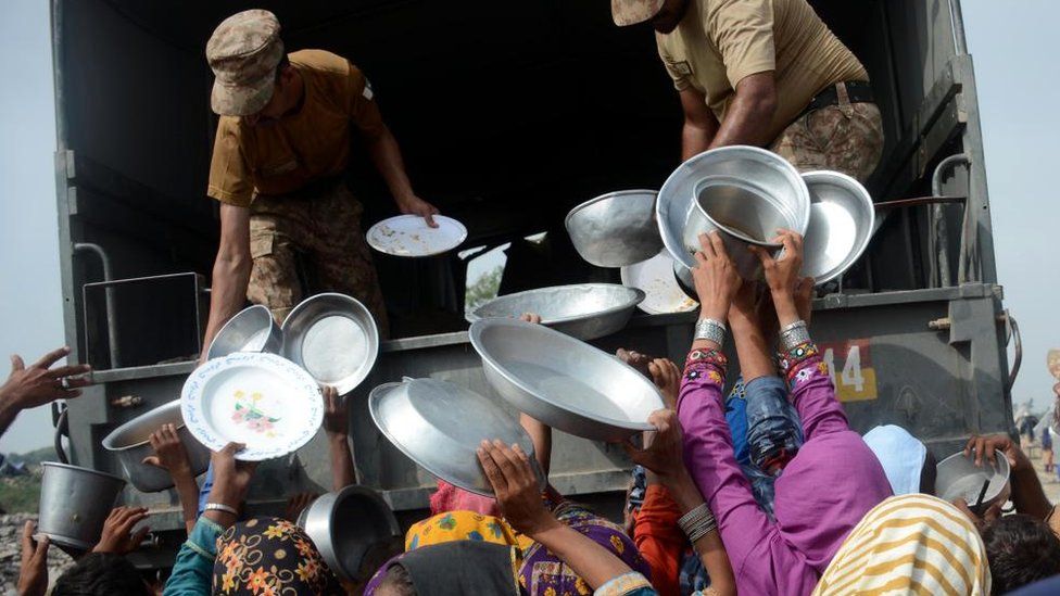 Солдаты пакистанской армии раздают еду пострадавшим от наводнения людям в районе Раджанпур, провинция Пенджаб, Пакистан, 27 августа 2022 г.