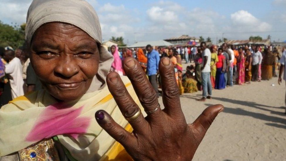 A woman shows her inked finger after casting her ballot at a polling station during the presidential and parliamentary election in Ubungo ward in the Kinondoni district of Dar es Salaam, 25 October 2015