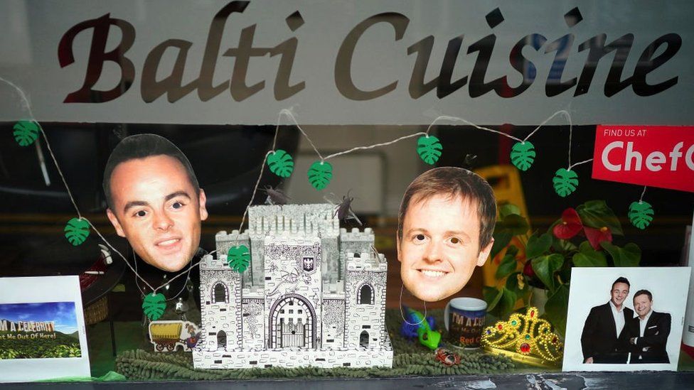 A window display featuring Ant and Dec in an Indian restaurant