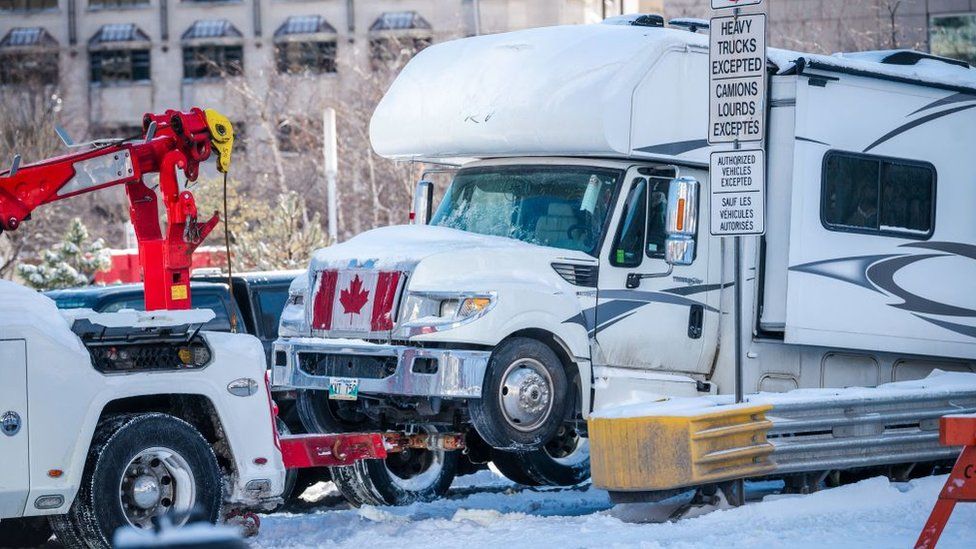 A recreational vehicle is towed as police begin to clear demonstrators against Covid-19 mandates in Ottawa on February 18, 2022.
