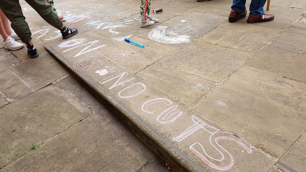 Chalk protest messages outside the meeting