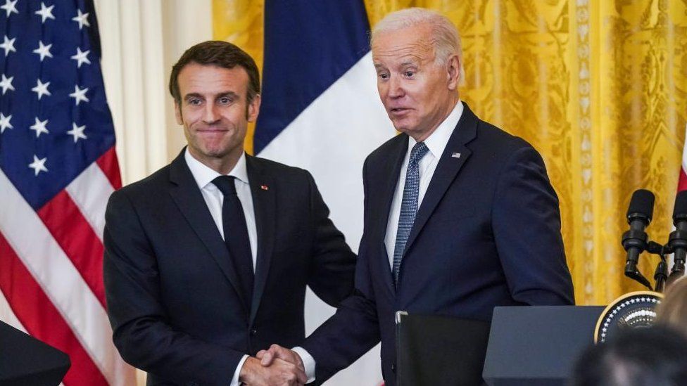 El presidente estadounidense Joe Biden (R) y el presidente francés Emmanuel Macron (L) se dan la mano después de hablar en una conferencia de prensa en la Sala Este de la Casa Blanca en Washington, DC, EE.UU., 01 de diciembre de 2022