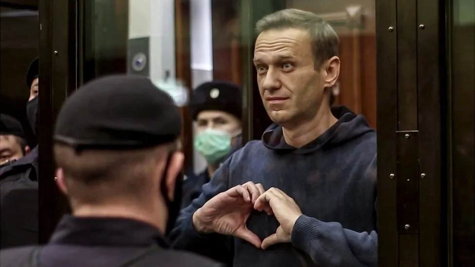 Image showing Alexei Navalny making a heart symbol with his hands while in court