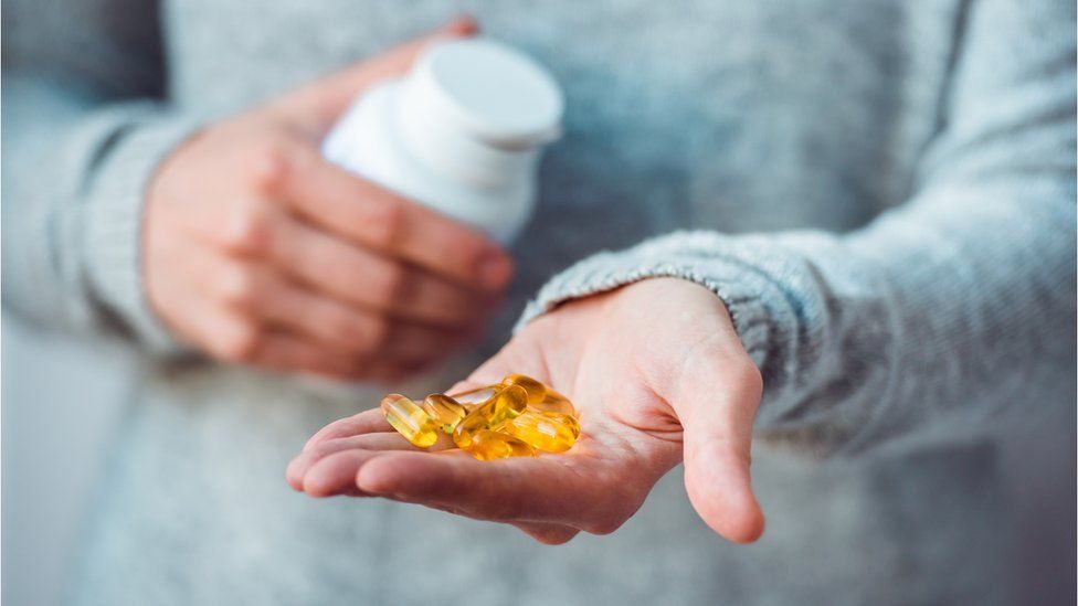 Fish oil supplements in a woman's hand
