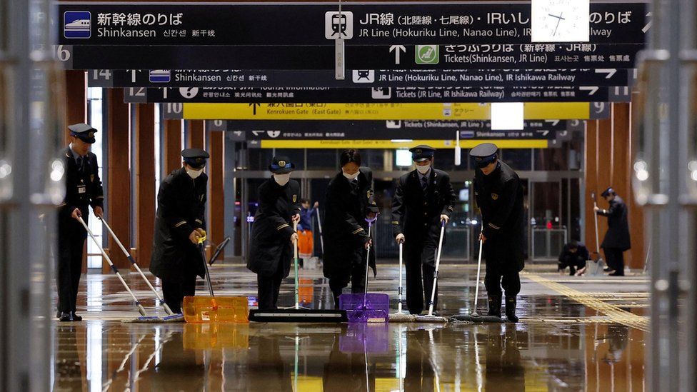 Railway workers try to remove water that leaked because of an earthquake at Kanazawa station in Kanazawa, Japan January 1, 2024, in this photo released by Kyodo.