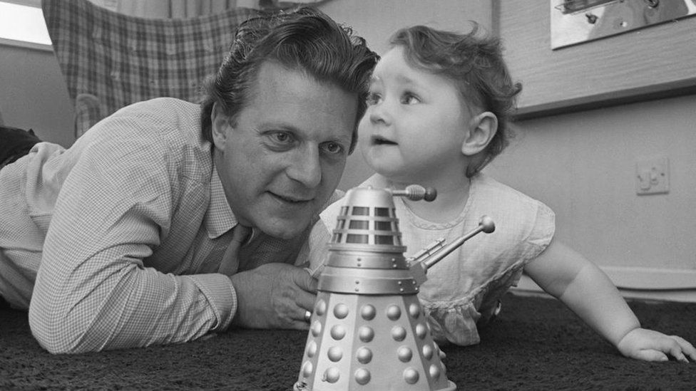 Raymond Cusick, designer of the Daleks from Doctor Who playing with his daughter and a toy Dalek.