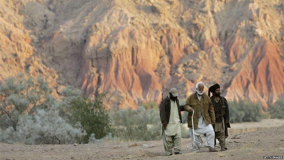 Guerrillas help Nawab Muhammad Akbar Bugti, 79, legendary chief of the Bugti tribe, during his daily exercise at a remote camp outside of Dera Bugti, in the province of Balochistan, Pakistan on January 22, 2006.