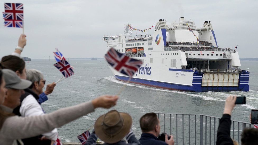 Crowds in Portsmouth waving Union and D-Day flags as the ferry passed