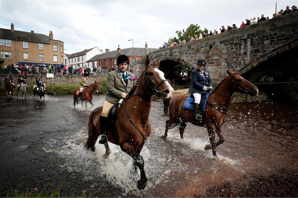 Horse and riders take part in the Riding of the Marches ford on the River Esk, alongside the Roman Bridge in Musselburgh, East Lothian, during the annual Musselburgh Festival