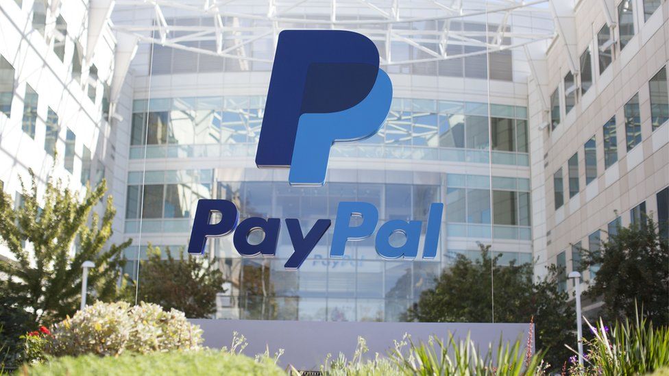 The PayPal logo is seen on a glass mount outside the company's offices in California