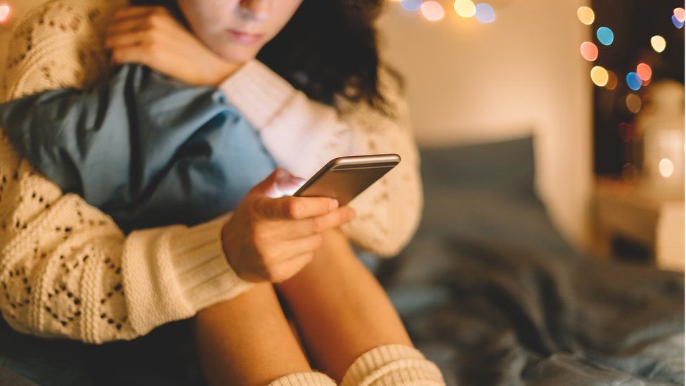 Girl texting on smartphone at home