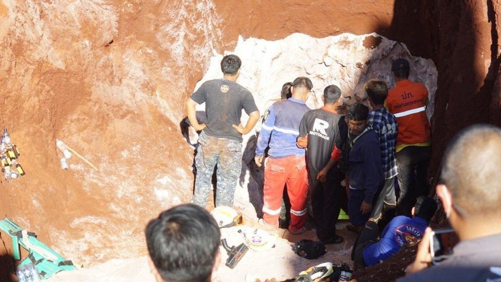 Rescue workers reach the side of the well shaft