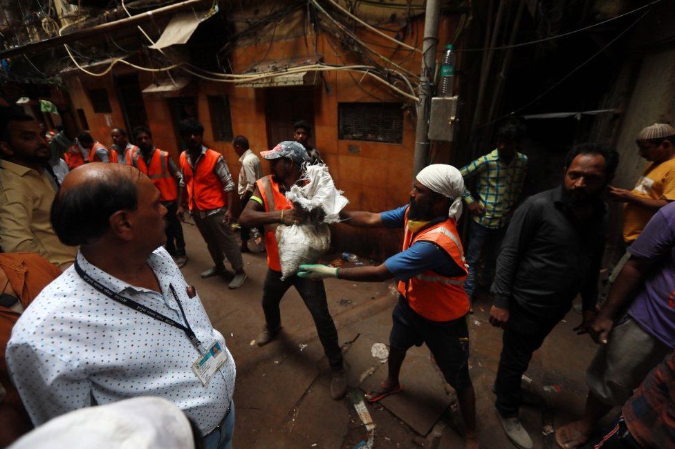 Municipal workers clear the debris from the site of collapsed building in Dongri area of Mumbai, India, 16 July 2019