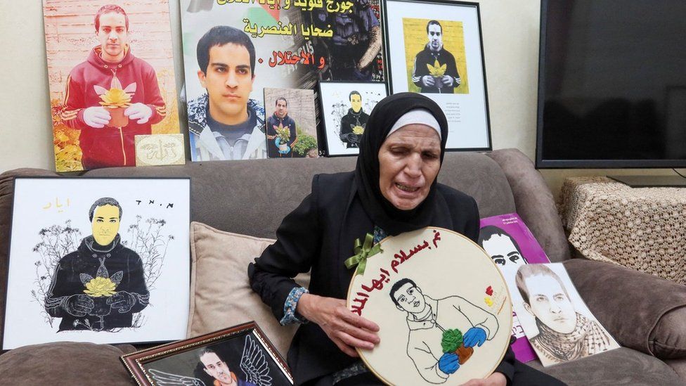 Rana Halaq holds up a picture of her son Iyad Halaq at her home in occupied East Jerusalem, following the Israeli court verdict acquitting the Israeli border police officer who killed him in May 2020