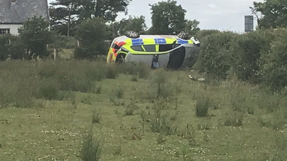 The car on its side in a field