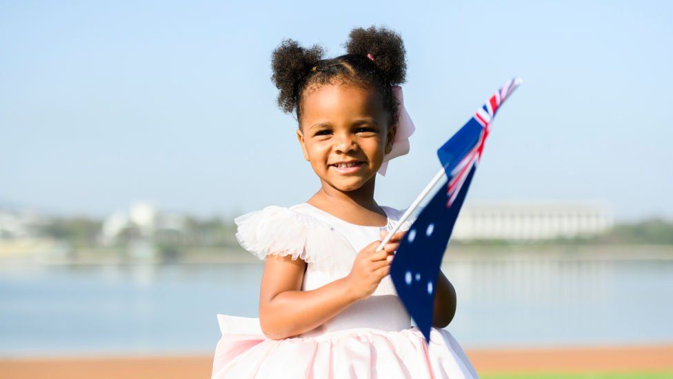 A young girl playing with an Australian flag