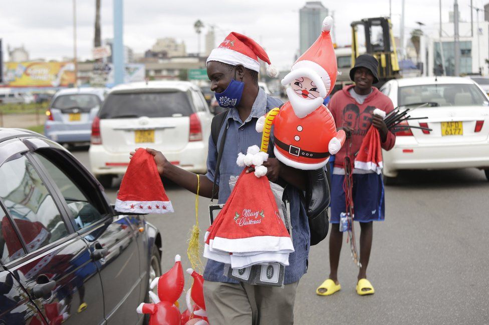 A vendor takes advantage of the Christmas spirit to sell red hats to passing motorists in Harare, Zimbabwe, 20 December 2021.