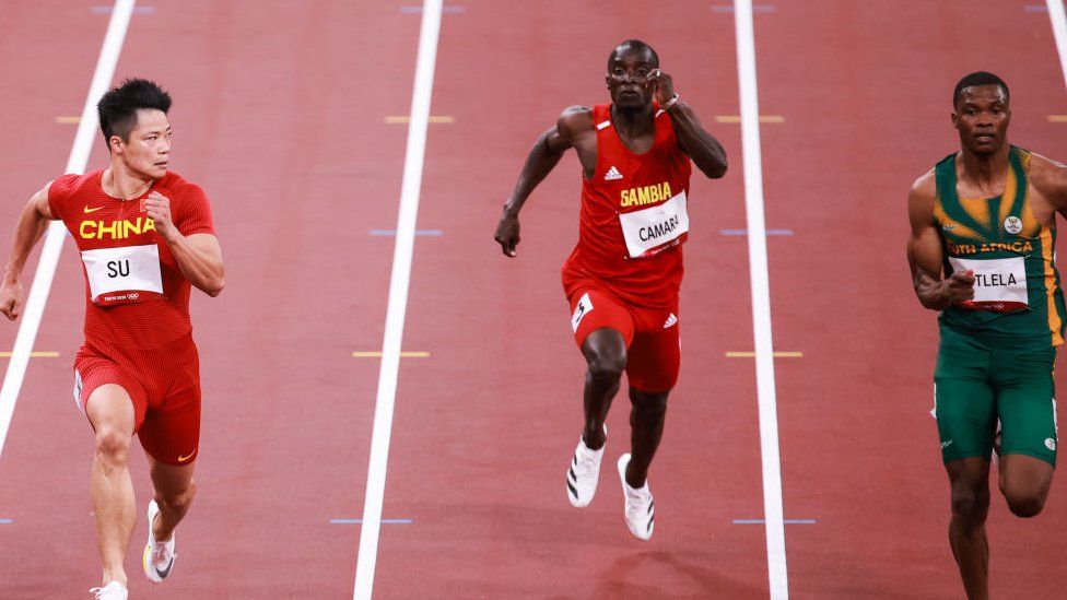 Su Bingtian of China, Ebrima Camara of Gambia, Gift Leotlela of South Africa compete in the Men's 100m Round 1 - Heat 4 on day eight of the Tokyo 2020 Olympic Games at Olympic Stadium on July 31, 2021 in Tokyo, Japan.