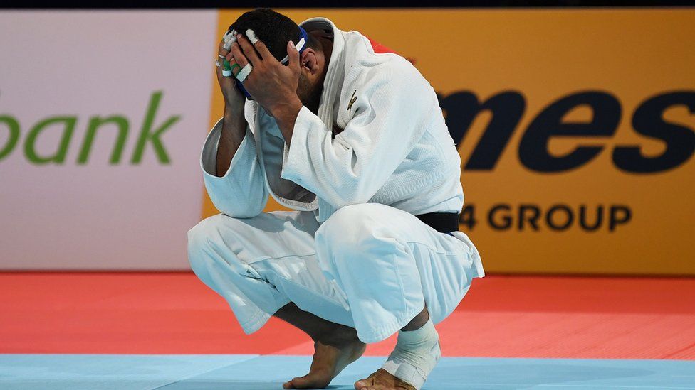 A judoka with his head in his hands