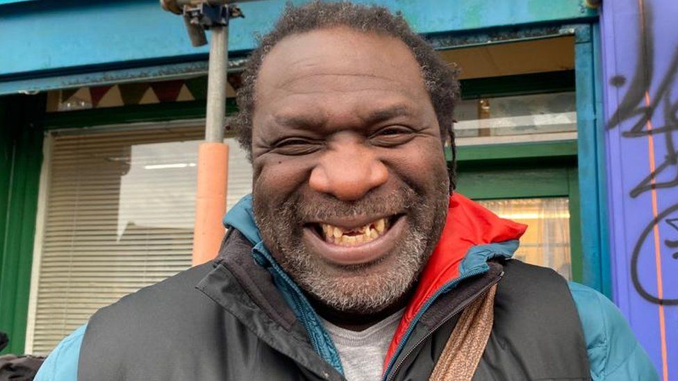 Miles Chambers in the queue for new dental practice smiling at the camera showing his teeth