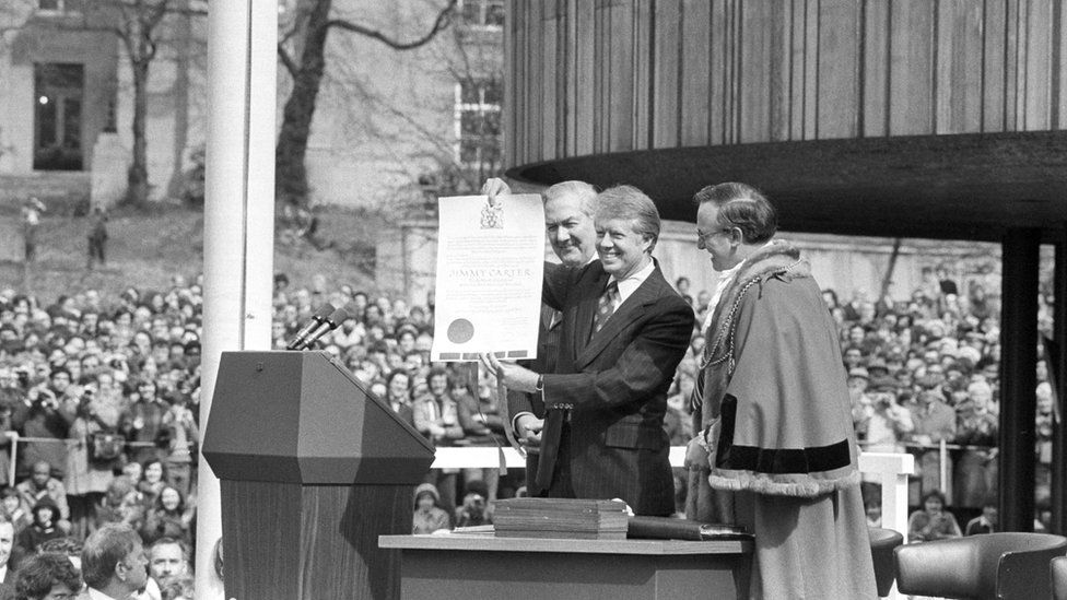 President Carter holds a scroll making him an honorary freeman of the city of Newcastle, 6 May 1977
