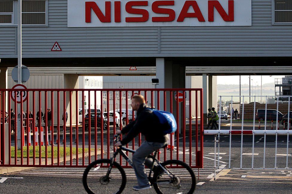 A man on a bicycle cycles past the Nissan car plant in Sunderland