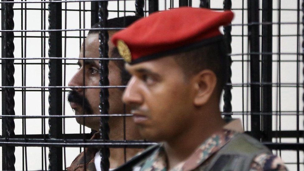 Maarik al-Tuwayha stands behind bars during his trial, for the killing of three American military trainers outside an army base last year, on July 17, 2017