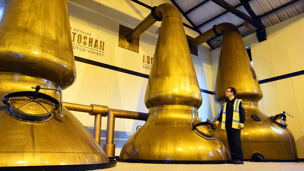 An employee checks the pot stills at the Auchentoshan Distillery near Glasgow