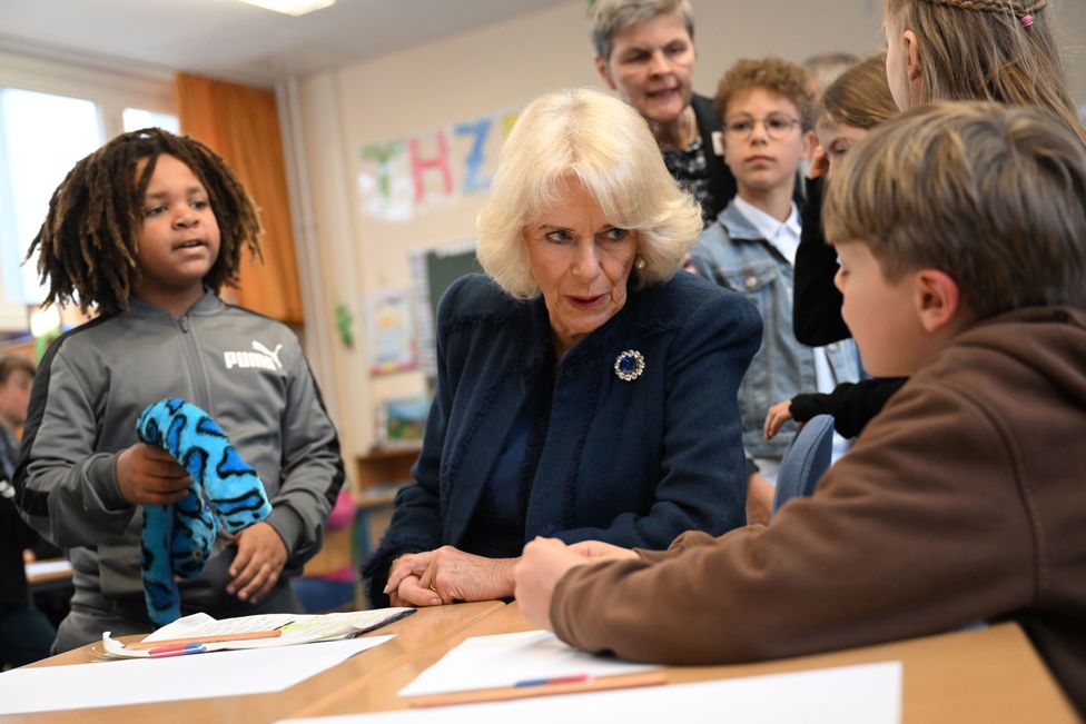 Камилла, королева-консорт Великобритании, разговаривает с ребенком во время посещения школы в Гамбурге, Германия, 31 марта 2023 г.