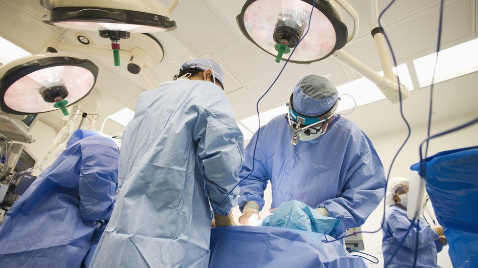 Surgeons working an a patient in a hospital operating theatre