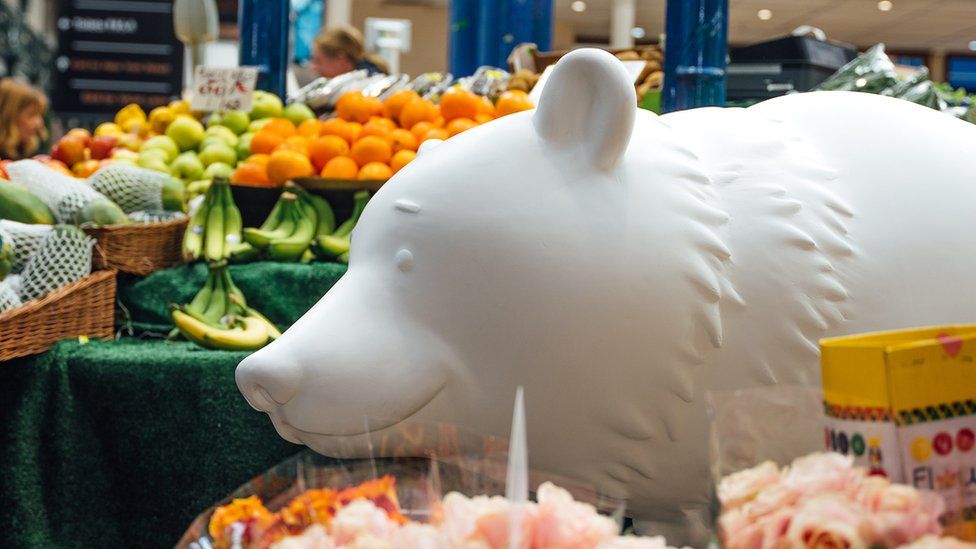 Weißer Bär inmitten eines Lebensmittelstandes auf dem Markt von Leeds