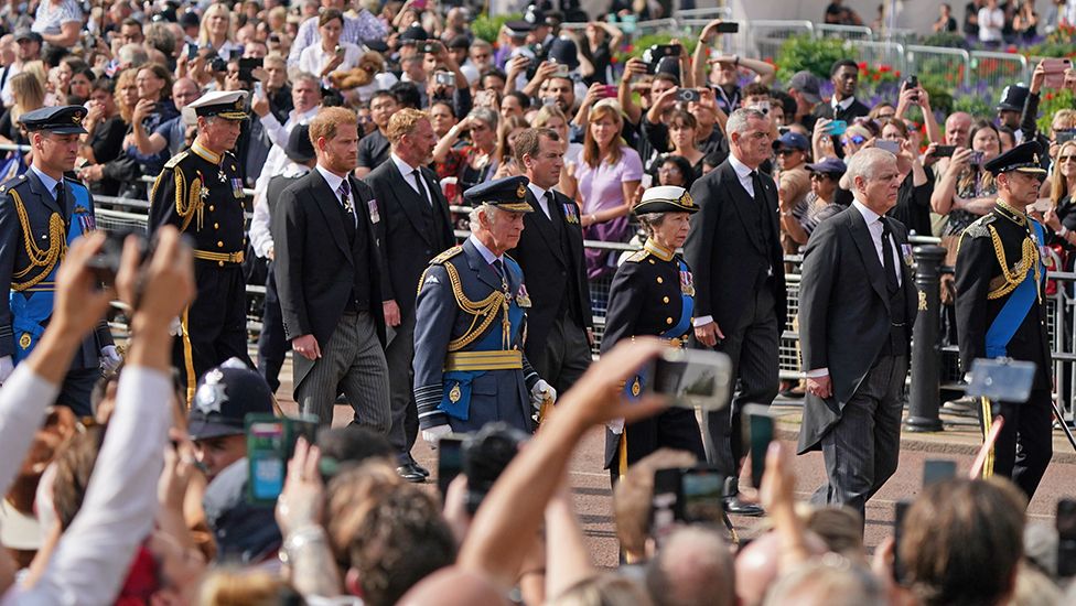 Король Карл III и члены королевской семьи за драпированным флагом гробом королевы Елизаветы II во время процессии на лафете королевской конной артиллерии из Букингемского дворца в Вестминстер-холл 14 сентября 2022 г.