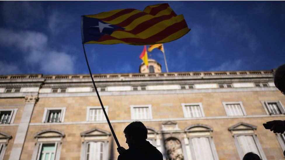 A man waves an independence flag outside the Palau Catalan Regional Government Building as Catalonia returns to work following last week"s decision by the Catalan parliament to vote to split from Spain on October 30, 2017 in Barcelona, Spain