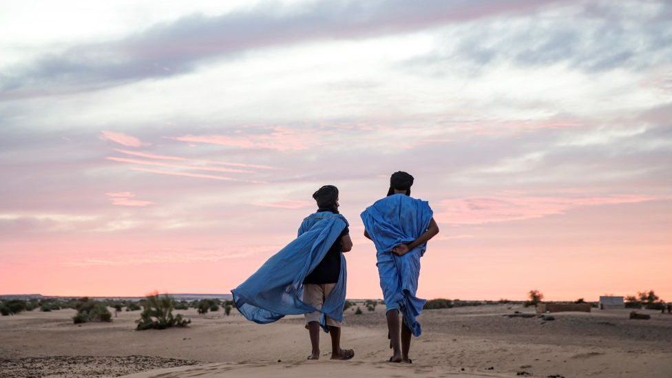 Two men walk in the desert of Guelb El Jmêl, in the eastern Mauritania on November 21, 2018.