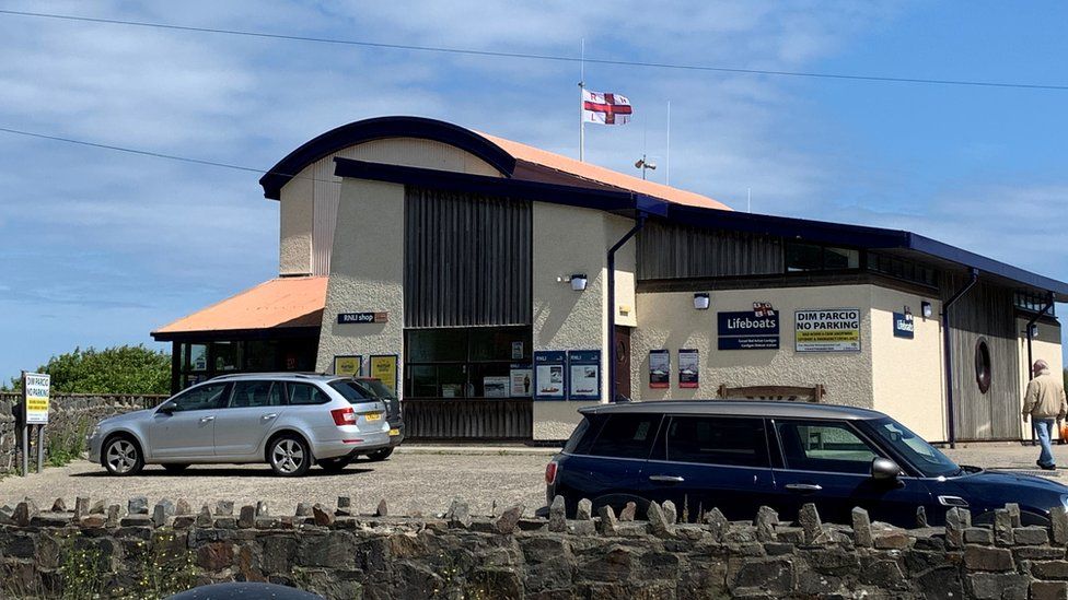 RNLI base at Poppit Sands with a flag flying at half mast