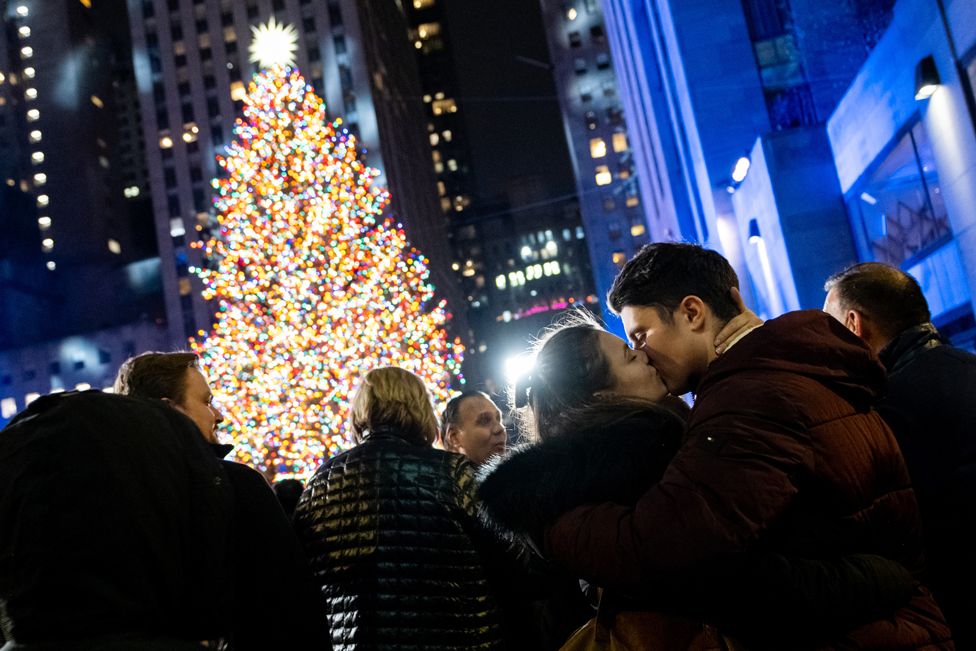 Two people kiss moments after the Rockefeller Christmas Tree is lit up at the annual ceremony on 1 December 2021, in New York City