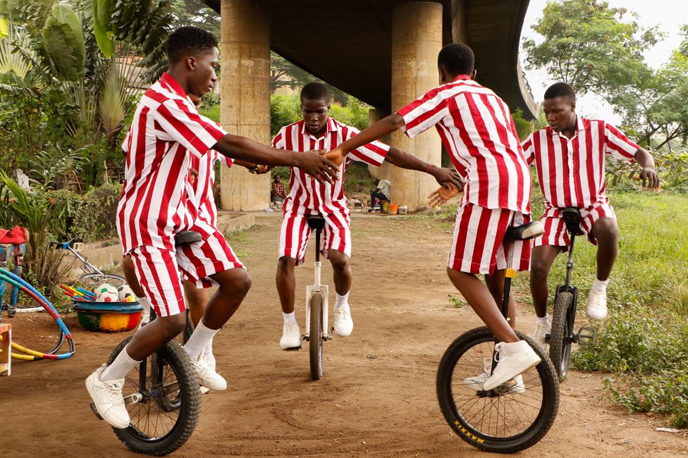Street children practise acrobatics on unicycles in Lagos, Nigeria - Monday 14 August 2023