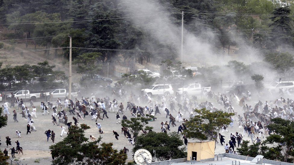 People run after an explosion during the funeral of one of the victims of the violent protests in Kabul