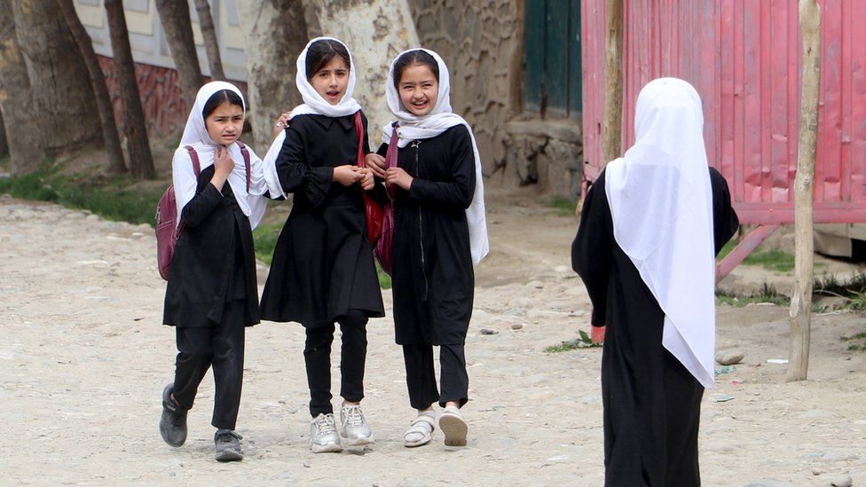 fghan primary school girls walk to their school to attend the first class following the start of the new academic year, along a street in Fayzabad district, Badakhshan province on March 20, 2024.