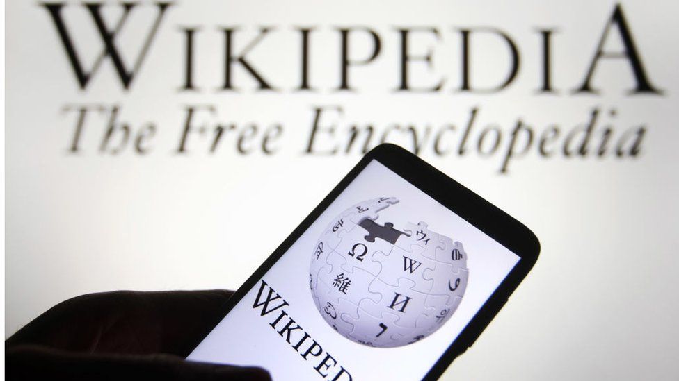 The Wikipedia logo is seen on a smartphone