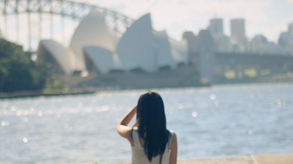 A woman stares at the Sydney skyline