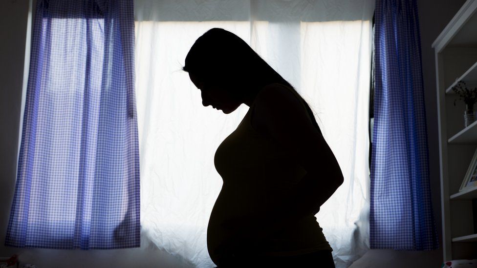 A silhouette of a pregnant woman