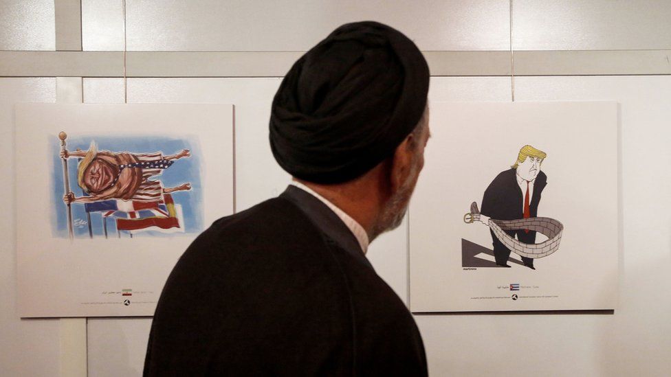 Iranian reformist cleric Mahmoud Doaei looks at cartoons of US President Donald Trump at an exhibition of the Islamic Republic's 2017 International Trumpism cartoon and caricature contest, in the capital Tehran on 3 July 2017