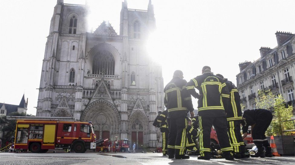 Firefighters are pictured in front of the cathedral