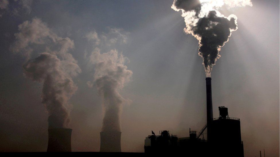 A coal-burning power plant can be seen behind a factory in China"s Inner Mongolia Autonomous Region