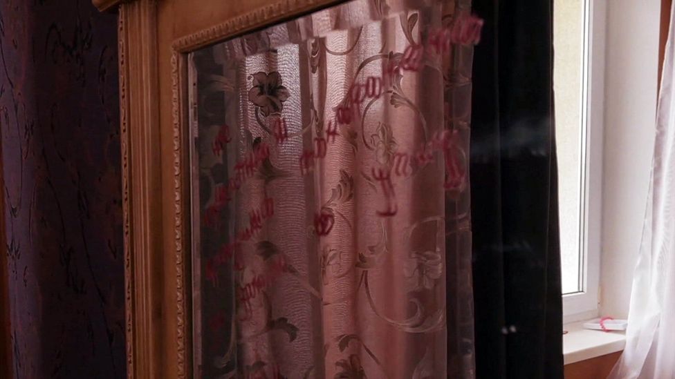 On the mirror in the bedroom a message in lipstick reads: "Tortured by unknown people, buried by Russian soldiers."