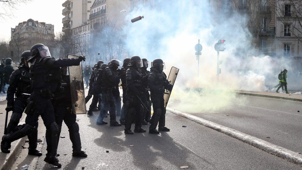 Police officers throw tear gas to protesters during the 13th consecutive Saturday demonstration called by the "Yellow Vests"